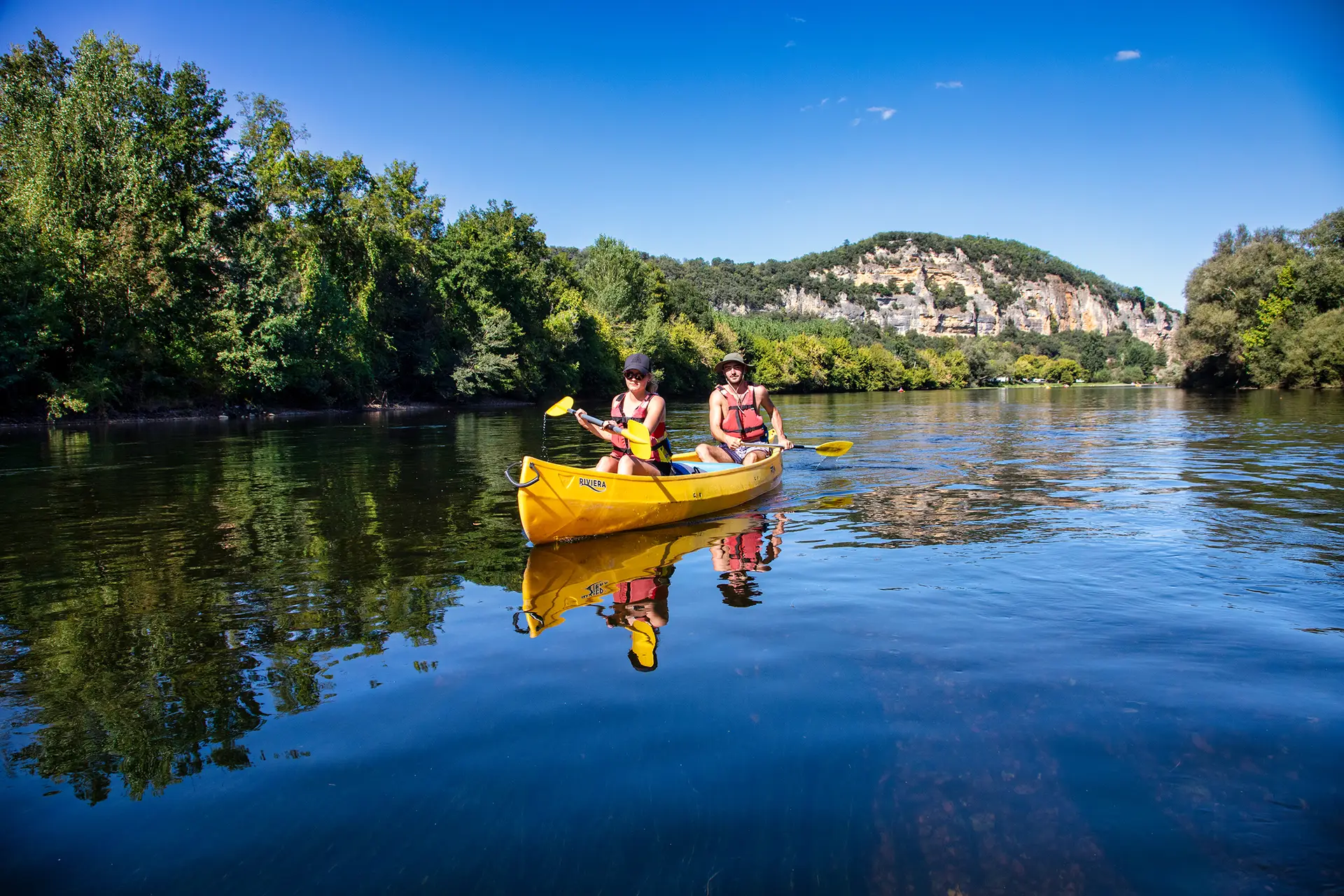 Canoë jaune devant le rocher le belvédère de Marquaysac