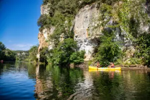 Couple qui pagaie sur la dordogne devant une falaise