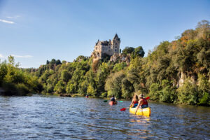 Couple qui pagaie sur la Dordogne devant le chateau de Montfort - Canoës Loisirs