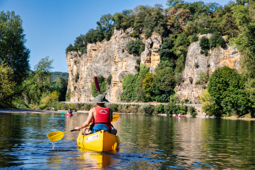 Couple qui pagaie dans Canoë sur la dordogne devant Falaise de Vitrac