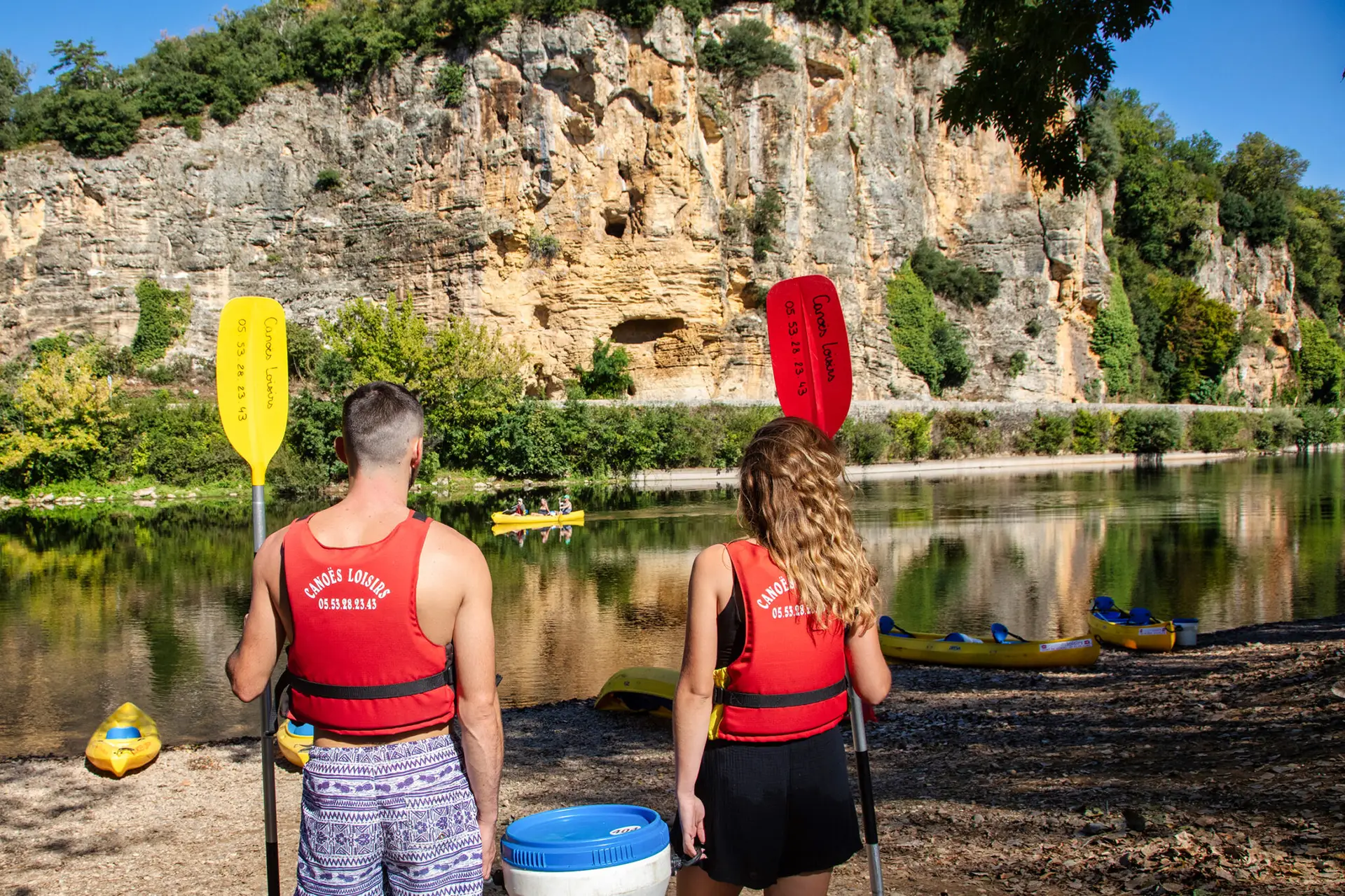 Deux personnes qui vont embarquer dans un canoës de Canoës Loisirs à Vitrac - Canoës Loisirs