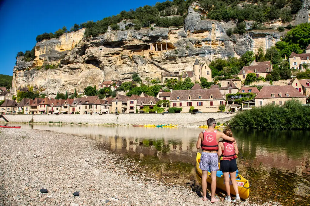 Couple sur la plage de galet devant la Roque Gageac en Dordogne - Balade Canoës Loisirs