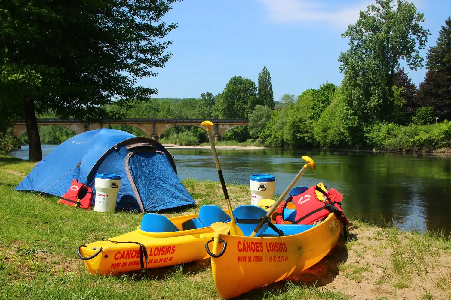 deux canoës jaunes canoës Loisis devant une tente de camping au bord de la dordogne